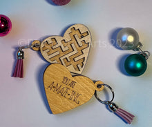 Load image into Gallery viewer, Valentine's Day gift, heart-shaped wooden maze puzzle with metal bead and clear acrylic top, with attached metal ring and colorful tassel by @belcreativearts